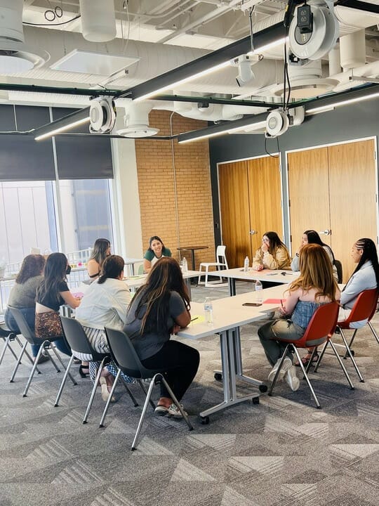 A group of women gathered around tables set up in a square