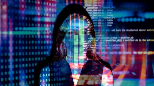 Person with long hair and a black top with colorful digital numbers, letters and shapes overlaid across the photo