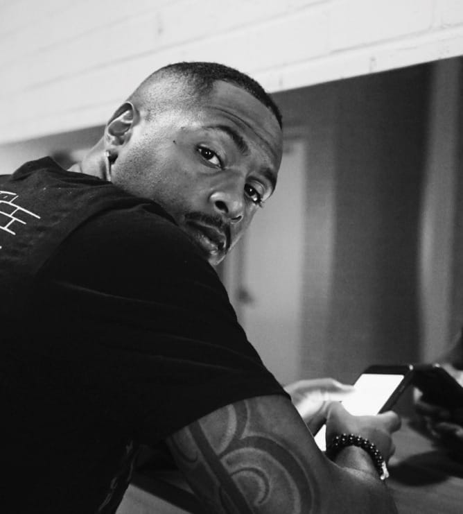 Person looking at the camera while holding a mobile phone with a bright screen