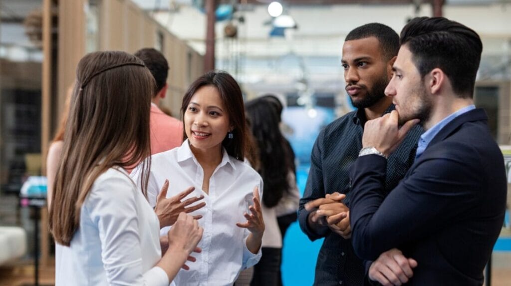 Four professional people talking to each other in an office setting