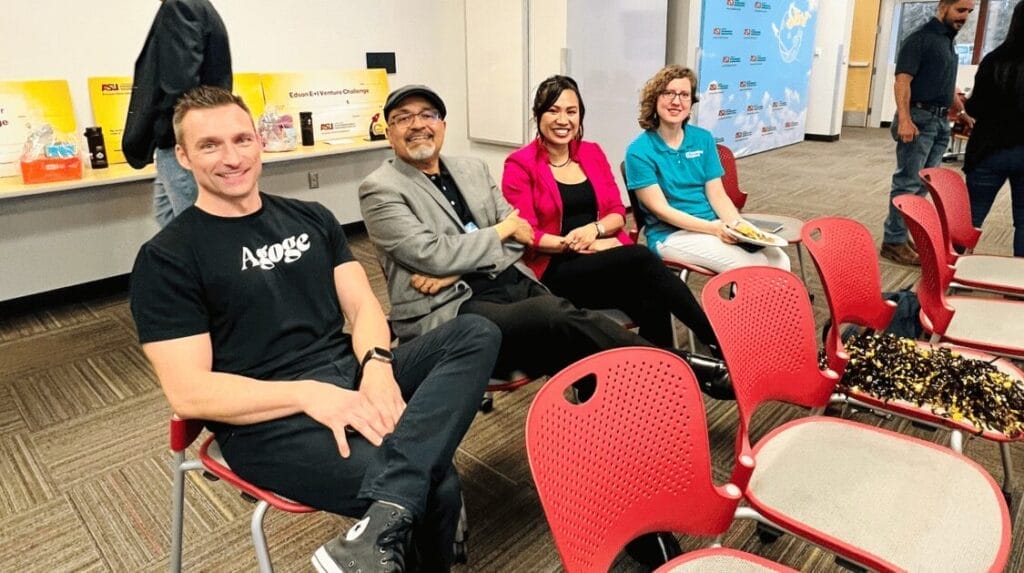 Four people sitting and smiling at a pitch contest event