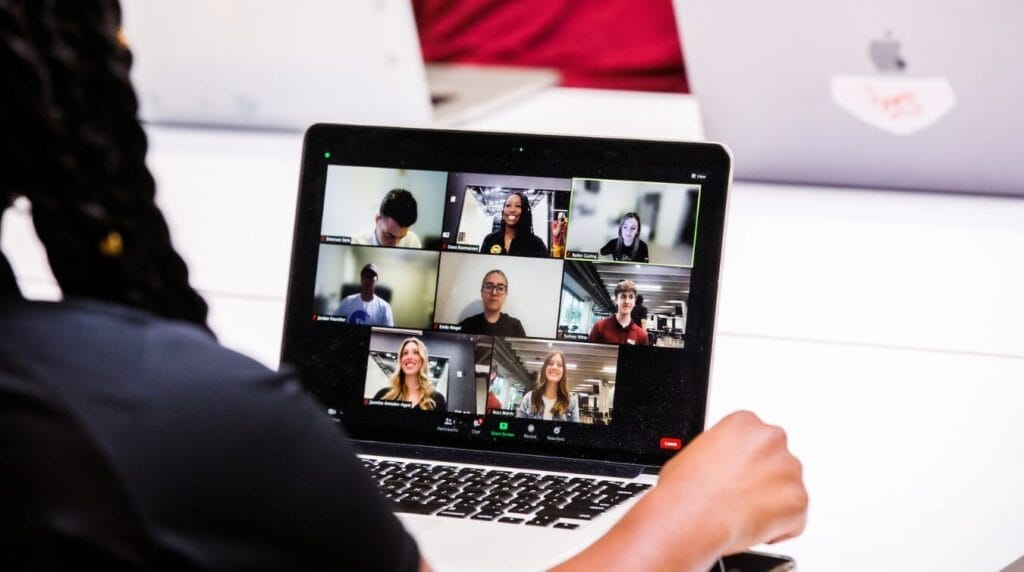 A person participating in a virtual meeting on their laptop
