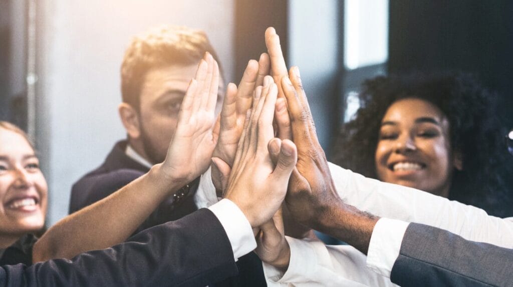 Coworkers high-fiving and smiling