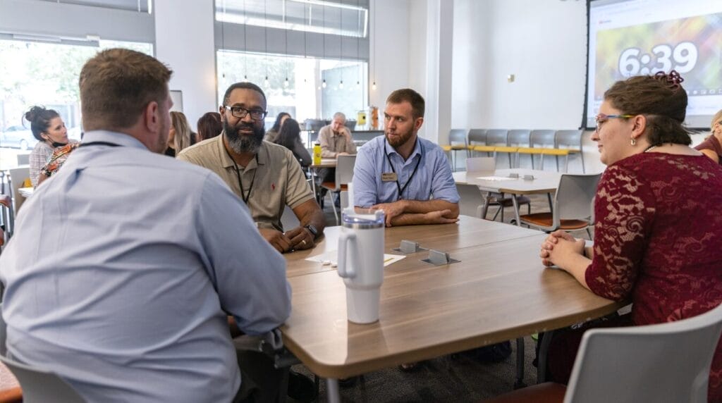 People sitting at a table at a professional event 