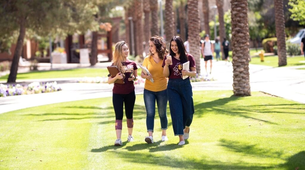 Three students walking on a college campus