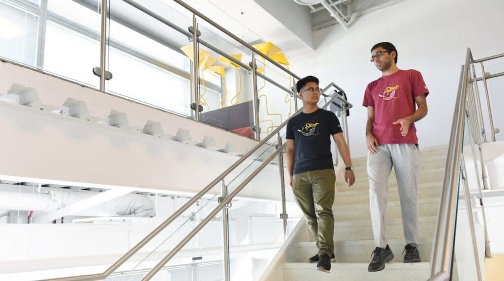 Two people walking down a stairway to work on their venture at a co-working space
