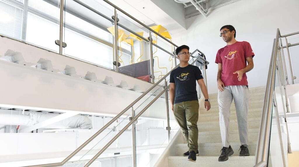 Two people walking down a stairway to work on their venture at a co-working space