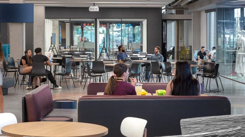 College students sitting at tables in a common space