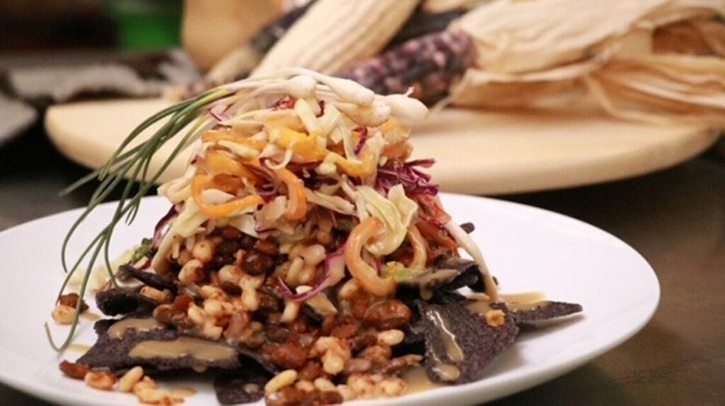 A plate of food with corn in the background