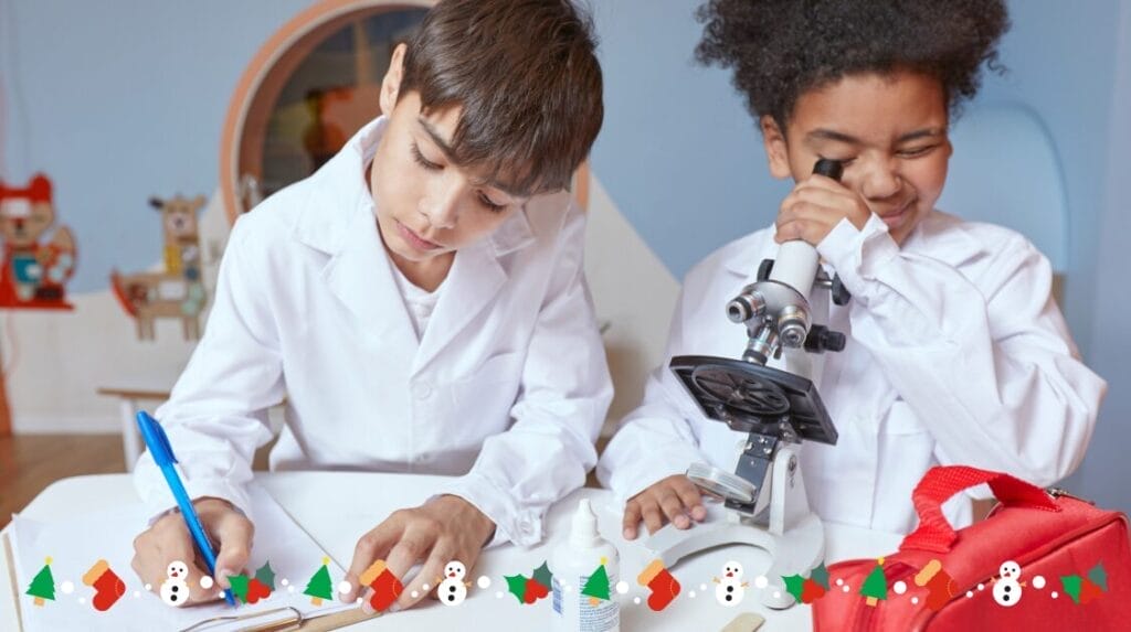 Two children wearing lab coats and working on a project with a microscope and a pad of paper