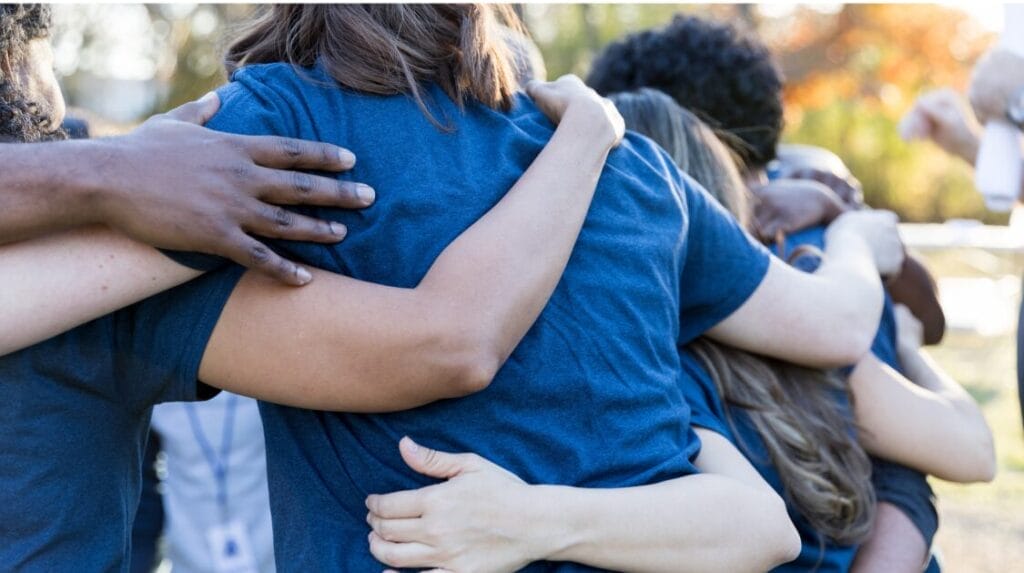 A group of people in a huddle outdoors