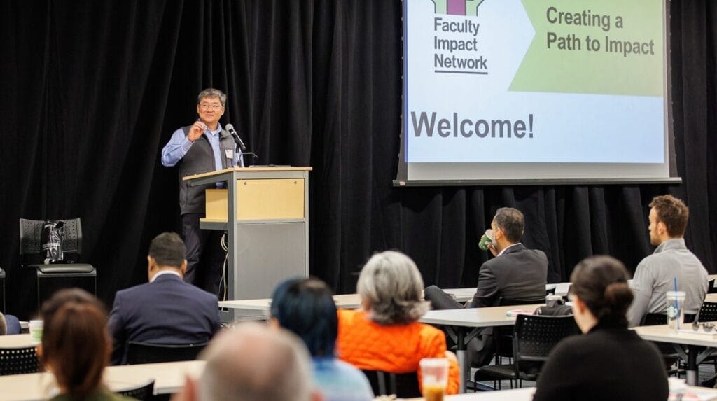 A person standing at a podium speaking to an audience