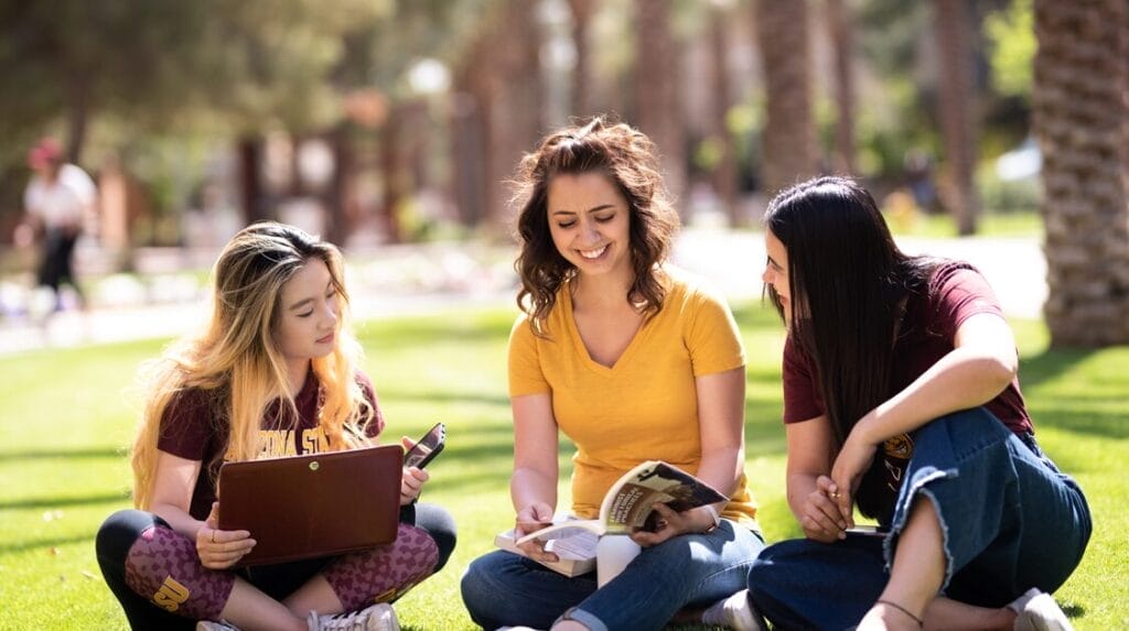 Three students sitting outdoors on the ASU campus