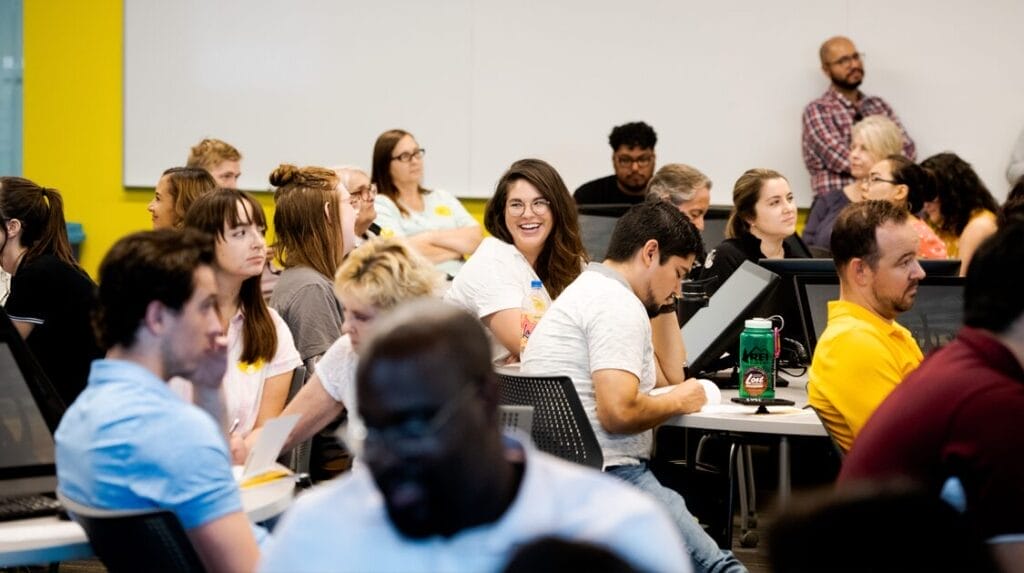 A group of people sitting at tables at an indoor professional event