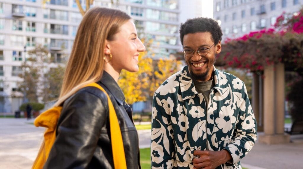Two college students walking and laughing outside.