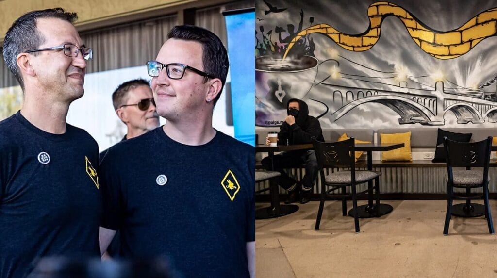 Two people standing next to each other and a person sitting at a table holding a coffee in a coffee shop with a painting of a yellow brick road, a bridge and a coffee cup.