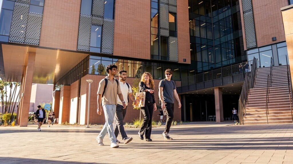 Four college students walking outside on the ASU campus. 