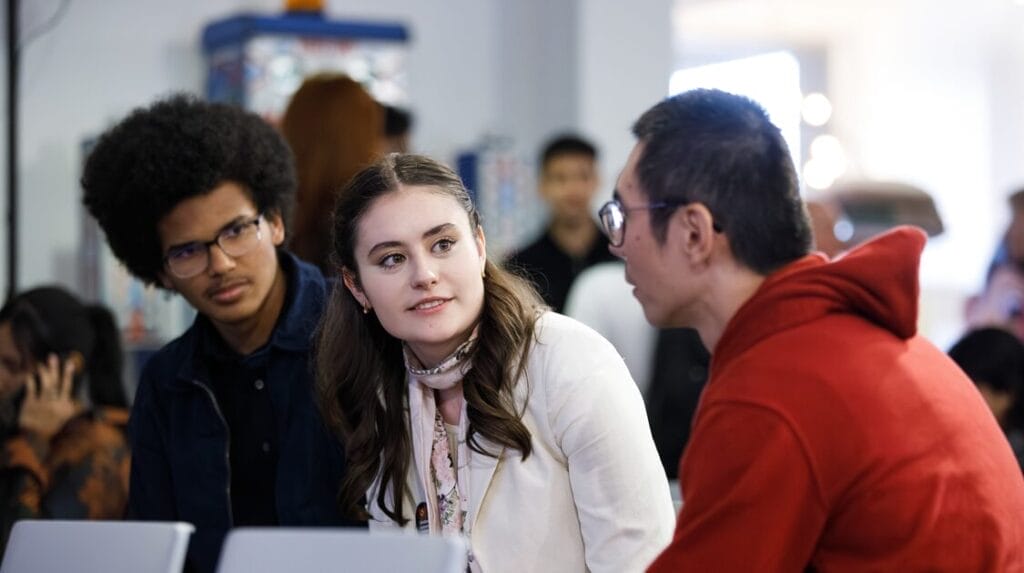 Three people sitting together at an event, deep in conversation.