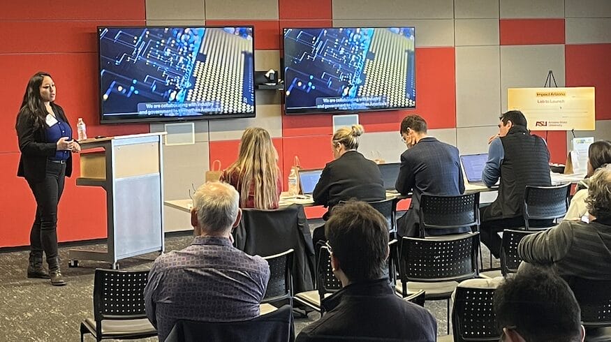 An entrepreneur standing in front of a panel of judges at a pitch event.