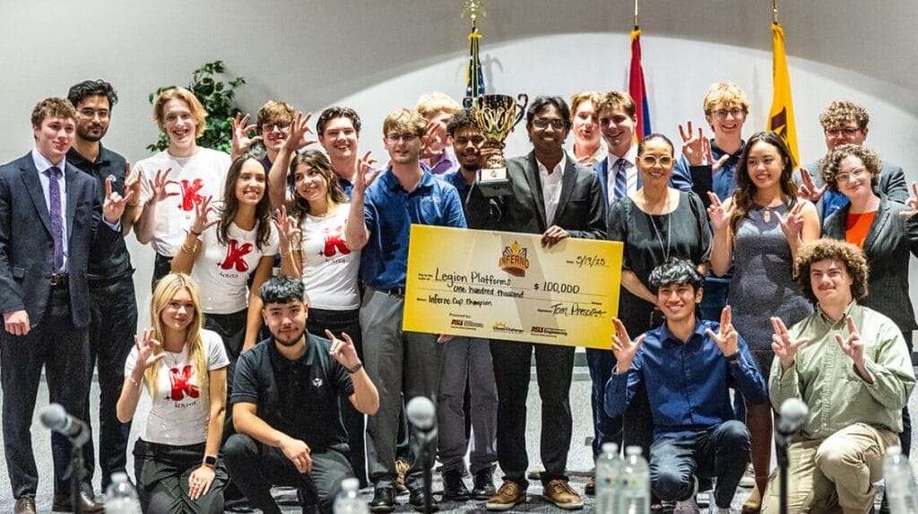 A group of college students smiling at the camera at a startup pitch event