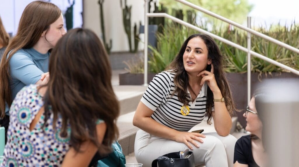 Four people sitting on stairs outside on the ASU campus talking and collaborating.