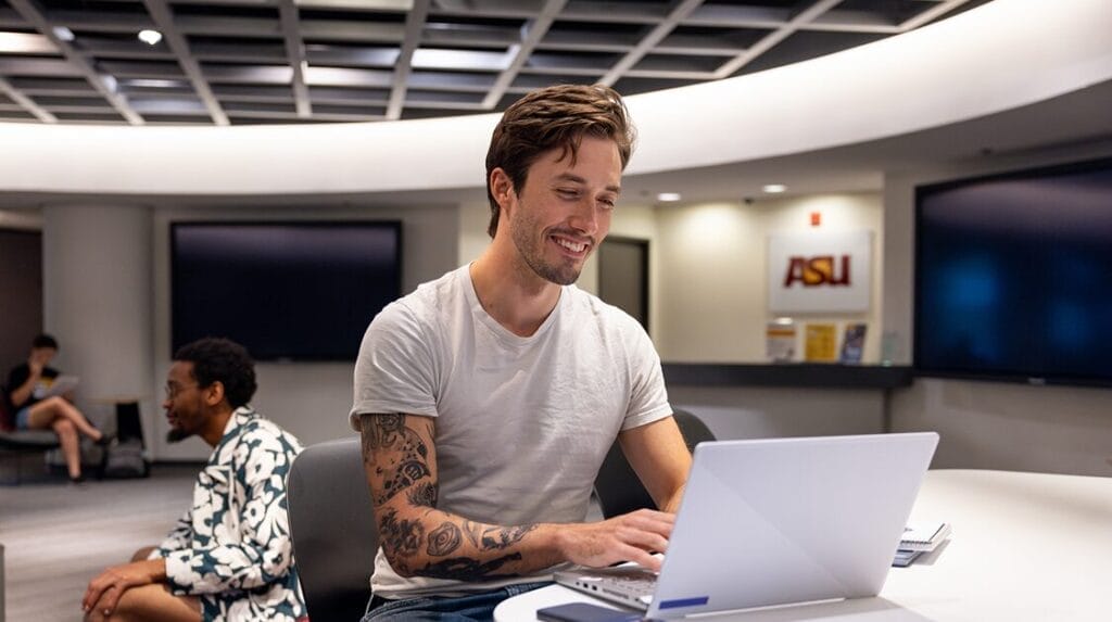A person sitting at a desk typing on their laptop.
