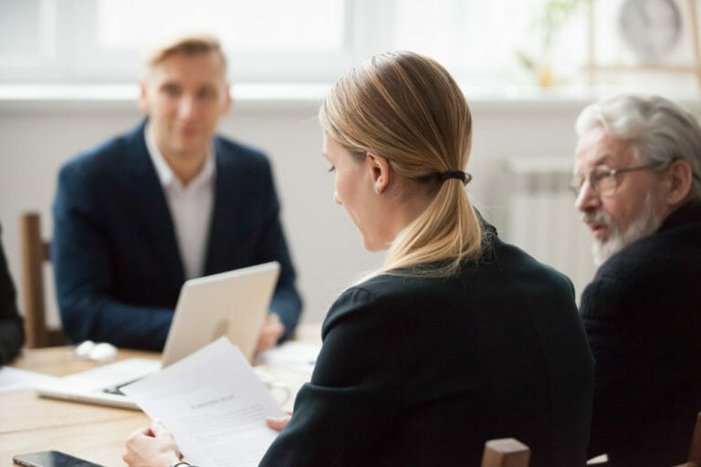 Man and woman sitting at a table reviewing documents.