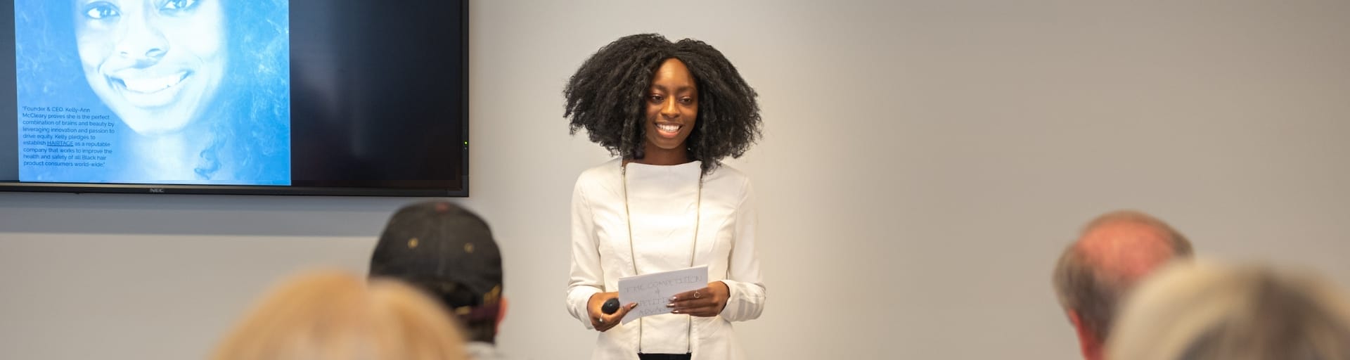 A speaker gives a slide deck presentation on a venture.