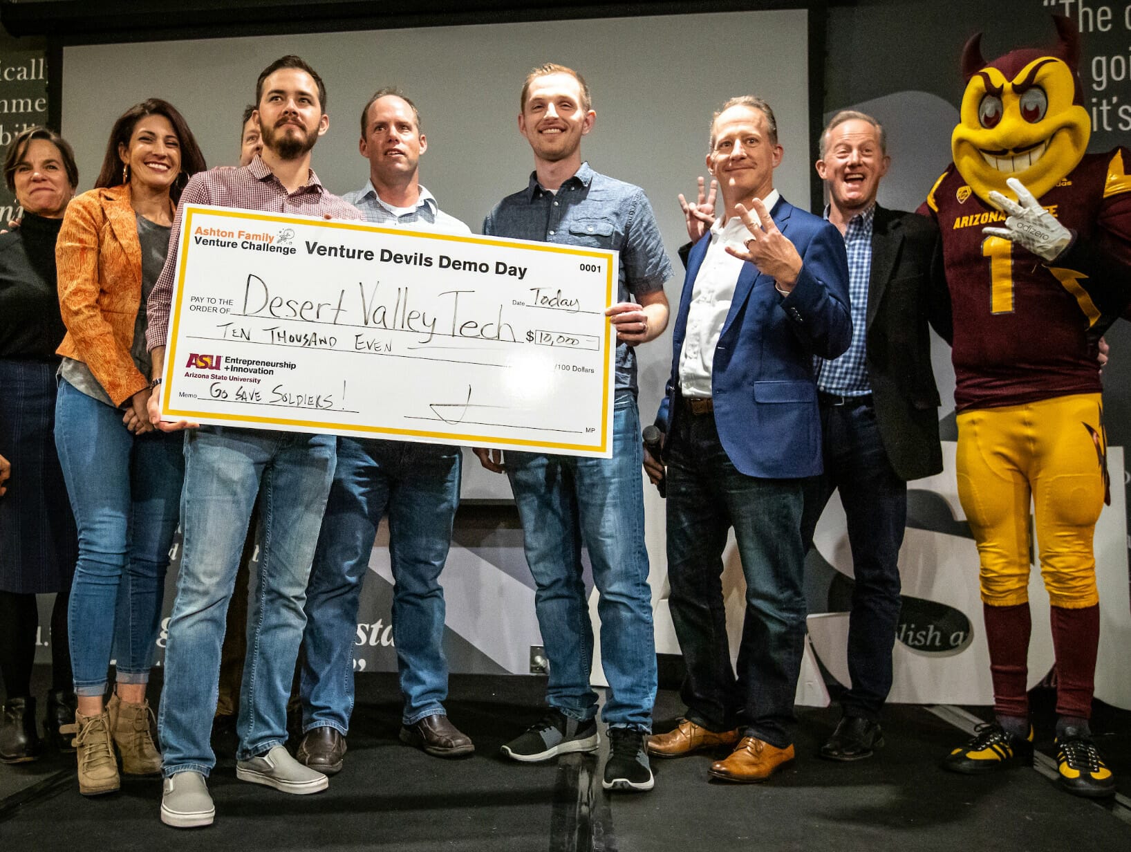 People standing with sparky and holding an oversized check