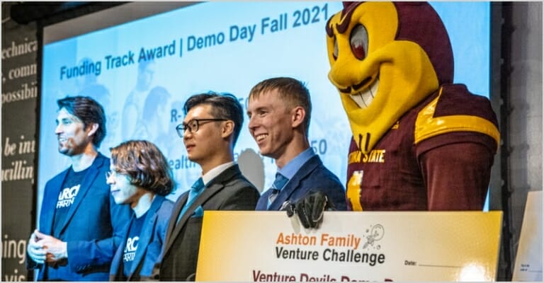 People standing on stage with Sparky