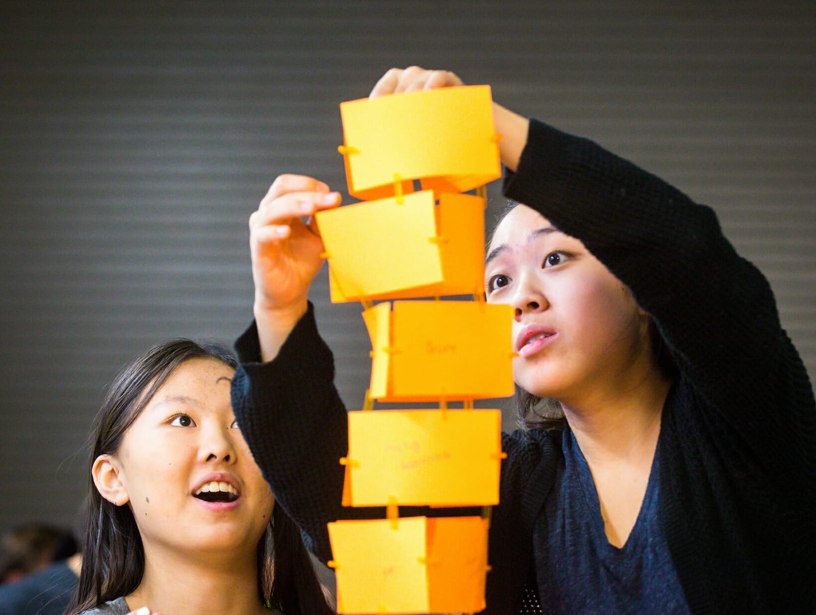 Students building a tower with paper ideas