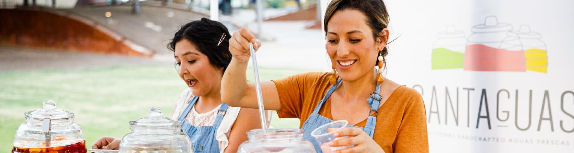 
		Two women work at their mobile food business serving handcrafted aguas frescas.		