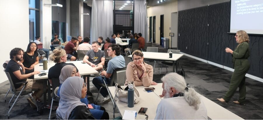 Large group of people sitting at tables with a speaker at Cultivate PHX: Agrifood Tech Incubator.